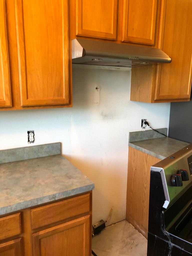 Dated kitchen with oak cabinets and worn countertop before a Maxter remodel