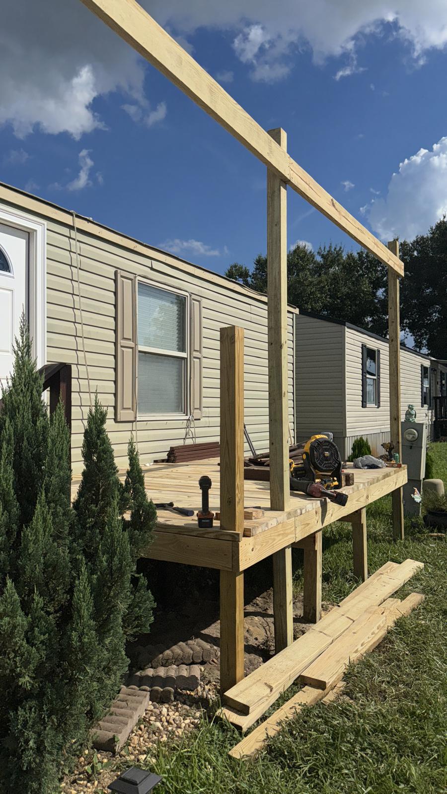 New pressure-treated deck framing and porch posts built onto a home