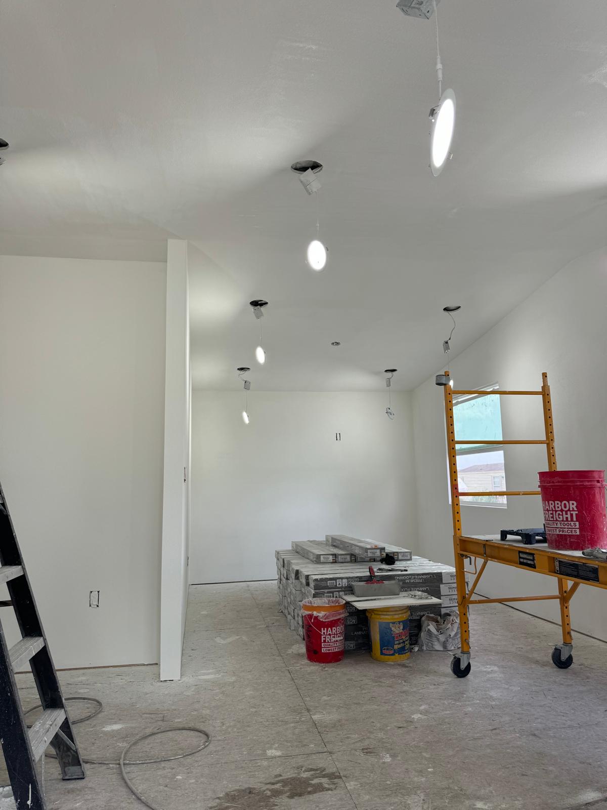 Interior room with finished drywall, recessed lighting and flooring ready to install